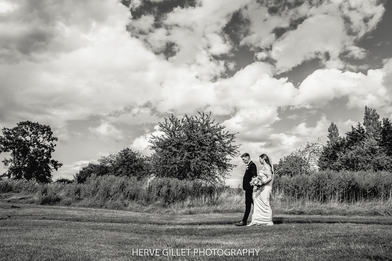 bride and groom walking in the field at Pryors Hayes Golf Club wedding photography
